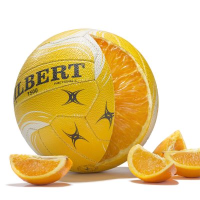 Photo composite image of a netball sliced open to reveal the inside is made of an orange.